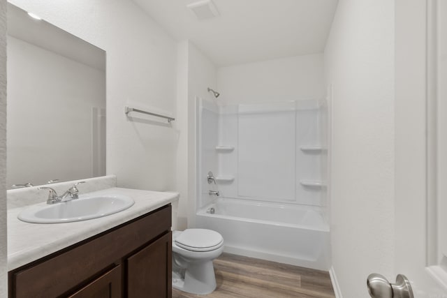 full bath with wood finished floors, toilet, vanity, and bathing tub / shower combination