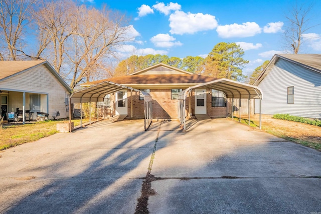 view of front of home featuring a detached carport, concrete driveway, and brick siding