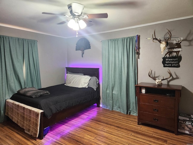 bedroom with wood finished floors, a ceiling fan, and ornamental molding