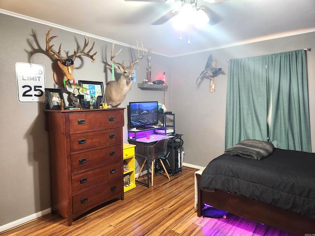 bedroom featuring ceiling fan, baseboards, wood finished floors, and crown molding