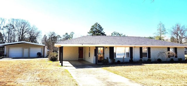 ranch-style home with an outbuilding, brick siding, a detached garage, and a front lawn