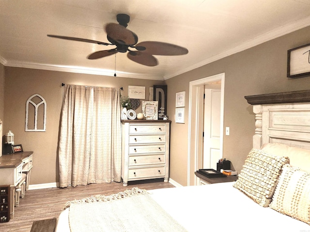 bedroom featuring baseboards, wood finished floors, ornamental molding, and a ceiling fan