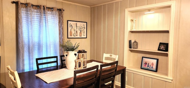 dining area with built in features and crown molding