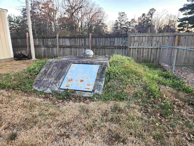 view of storm shelter with a fenced backyard