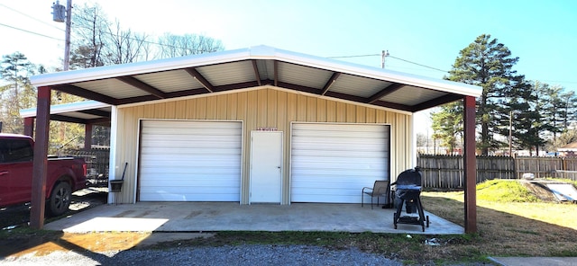 garage with a detached garage and fence