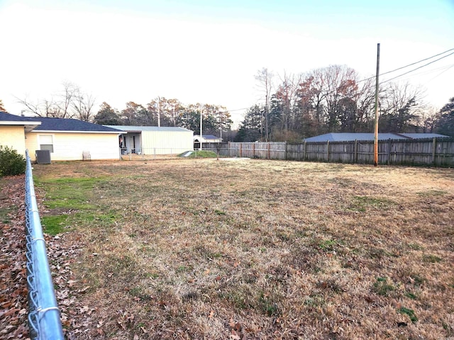 view of yard featuring central AC unit and fence