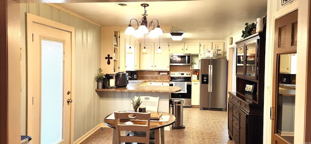 kitchen with an inviting chandelier, a peninsula, ornamental molding, stainless steel appliances, and pendant lighting