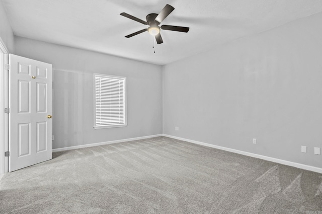 unfurnished room with a ceiling fan, carpet, and baseboards