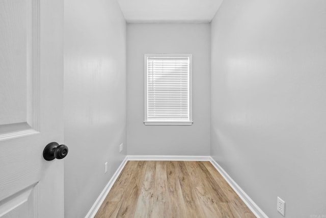 empty room featuring light wood-type flooring and baseboards