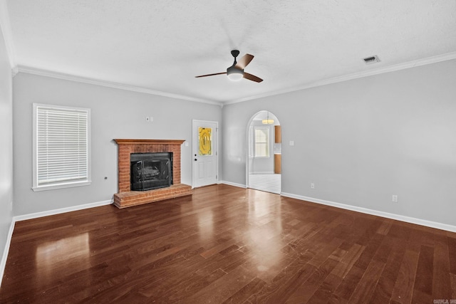 unfurnished living room with arched walkways, a fireplace, baseboards, and wood finished floors