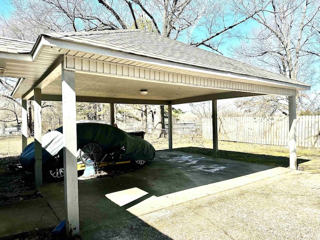 view of parking featuring a detached carport and fence