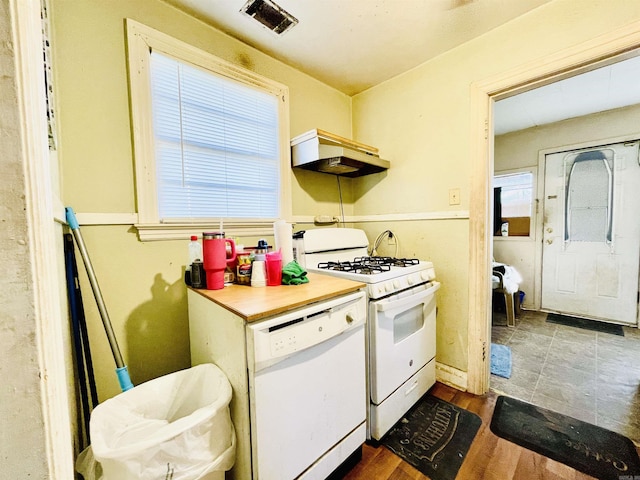 kitchen featuring dark wood-style floors, gas stove, visible vents, under cabinet range hood, and dishwasher