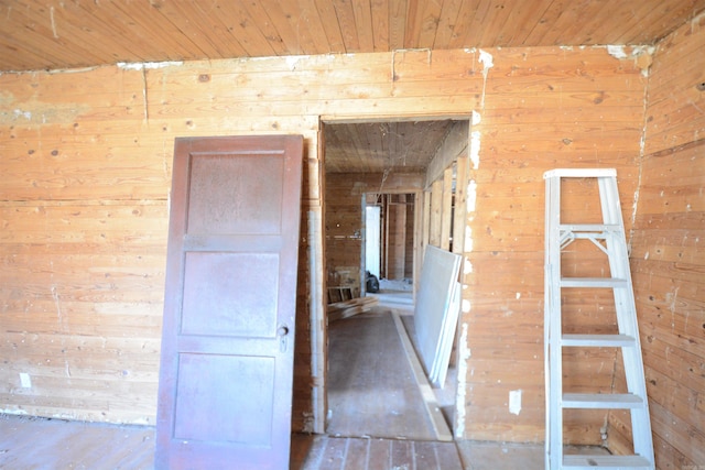 interior space featuring wooden ceiling and wood walls