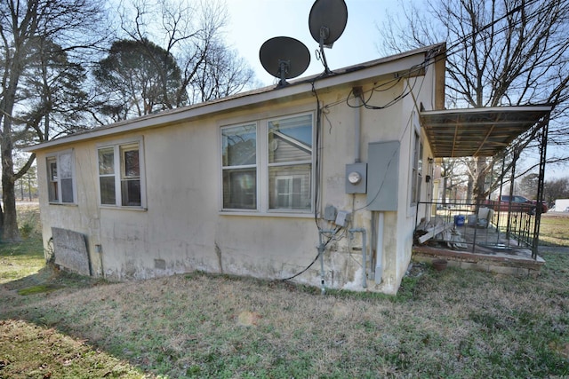 view of home's exterior with stucco siding and a yard