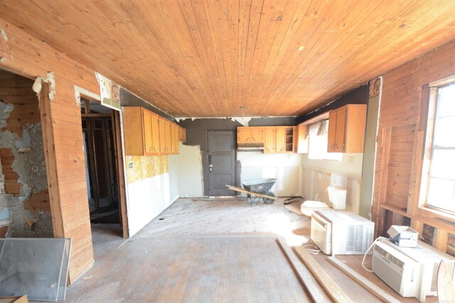 kitchen with a healthy amount of sunlight, wooden ceiling, and wood walls