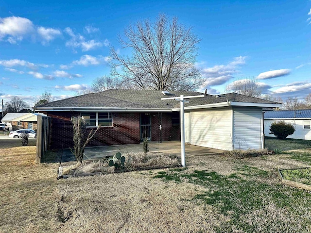 back of property with a patio, a yard, and brick siding