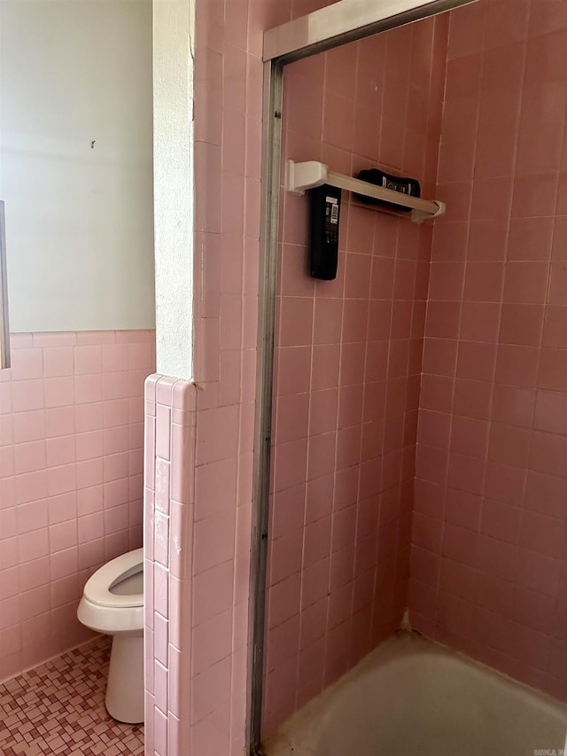 full bath with a shower with shower door, a bathing tub, wainscoting, tile walls, and toilet