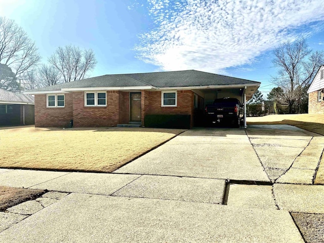 ranch-style home featuring an attached carport, brick siding, and driveway