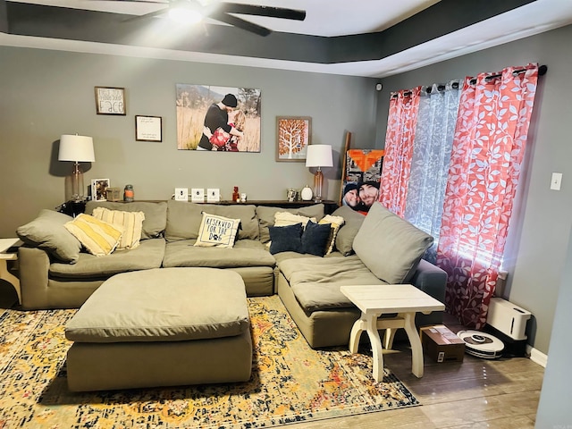 living room with a ceiling fan and baseboards