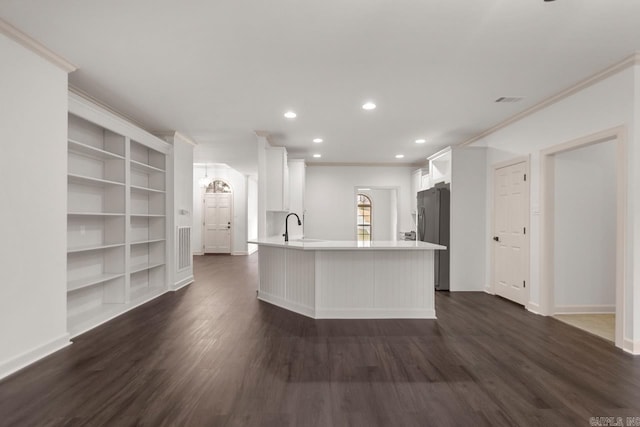 kitchen with dark wood-type flooring, white cabinets, light countertops, and freestanding refrigerator