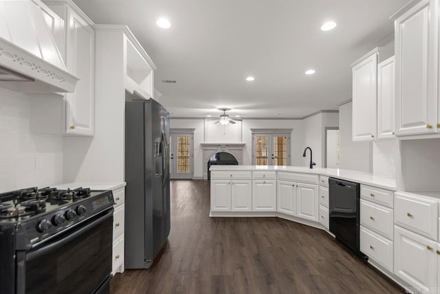 kitchen with under cabinet range hood, a peninsula, black appliances, and light countertops