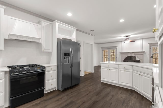 kitchen with light countertops, black range with gas cooktop, stainless steel fridge, white cabinetry, and a sink