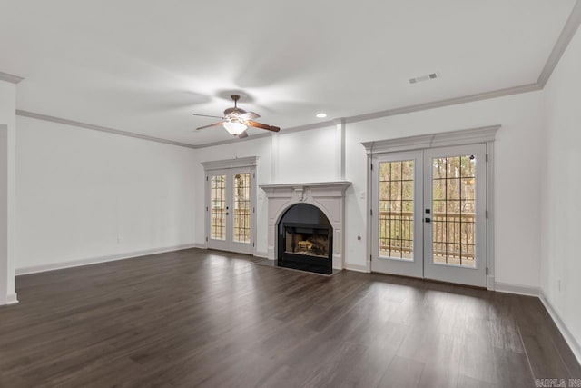 unfurnished living room featuring visible vents, dark wood finished floors, a fireplace with flush hearth, ornamental molding, and french doors