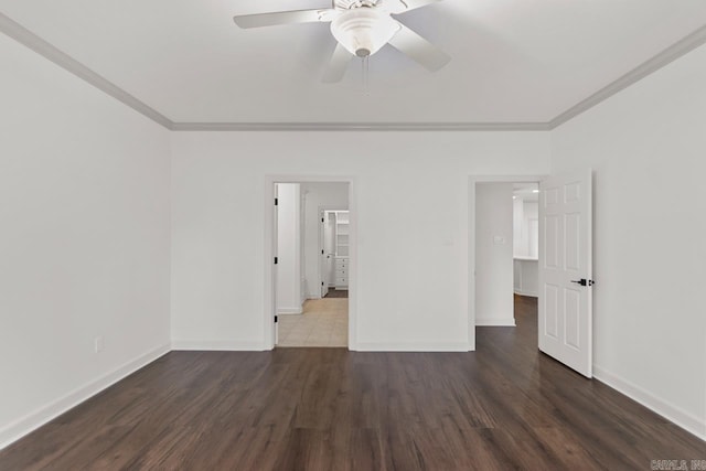 empty room with ceiling fan, crown molding, baseboards, and wood finished floors