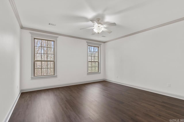 spare room featuring visible vents, crown molding, baseboards, dark wood finished floors, and a ceiling fan