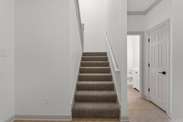 stairs with tile patterned flooring, baseboards, and ornamental molding