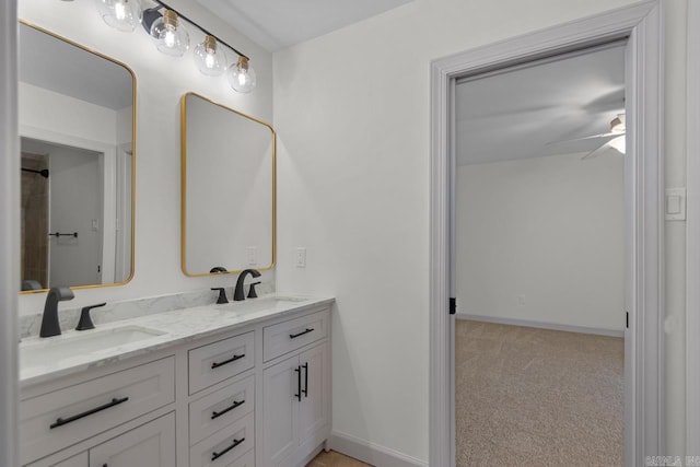 full bathroom with double vanity, baseboards, and a sink