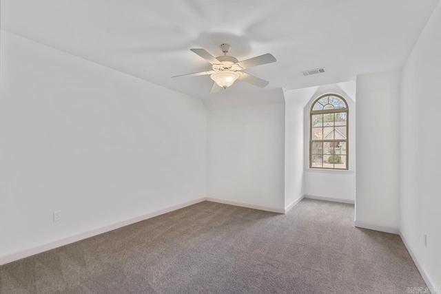 carpeted empty room with baseboards, visible vents, and ceiling fan