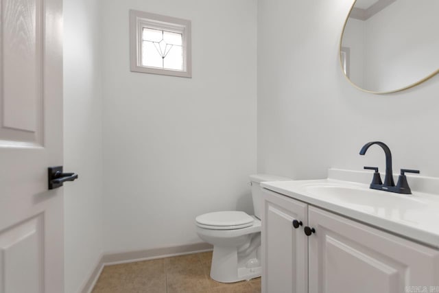 half bath featuring tile patterned floors, baseboards, toilet, and vanity