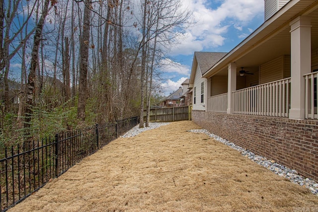 view of yard featuring a fenced backyard and ceiling fan