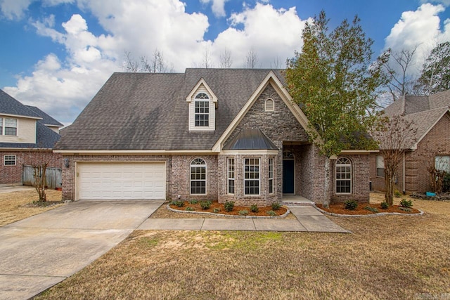 view of front of house featuring roof with shingles, concrete driveway, a front yard, a garage, and brick siding