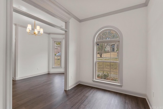 empty room with plenty of natural light, a notable chandelier, ornamental molding, and dark wood finished floors