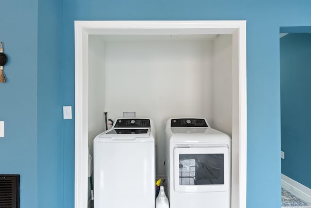 washroom with visible vents, marble finish floor, baseboards, laundry area, and washing machine and clothes dryer