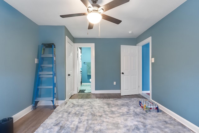 bedroom featuring ceiling fan, baseboards, and wood finished floors