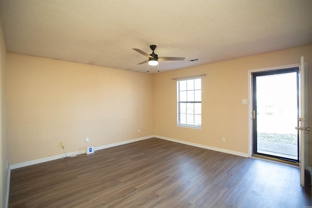 empty room featuring visible vents, a textured ceiling, baseboards, ceiling fan, and dark wood-style flooring