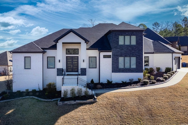 view of front facade featuring a front lawn, a garage, and a shingled roof