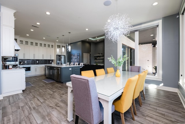 dining space with recessed lighting, visible vents, and wood finished floors