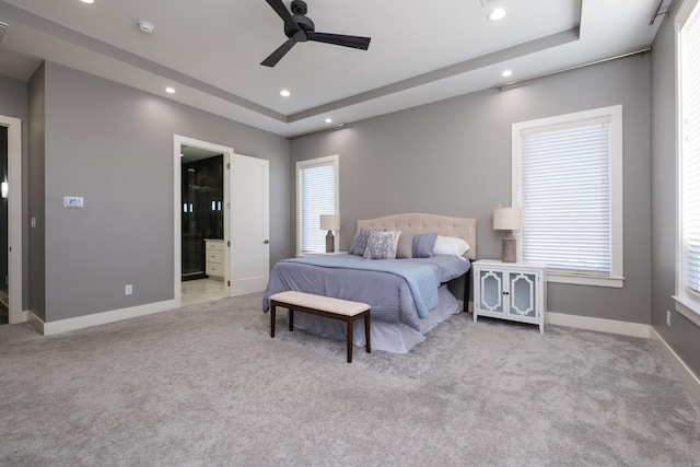 bedroom with baseboards, carpet, recessed lighting, ensuite bath, and a raised ceiling