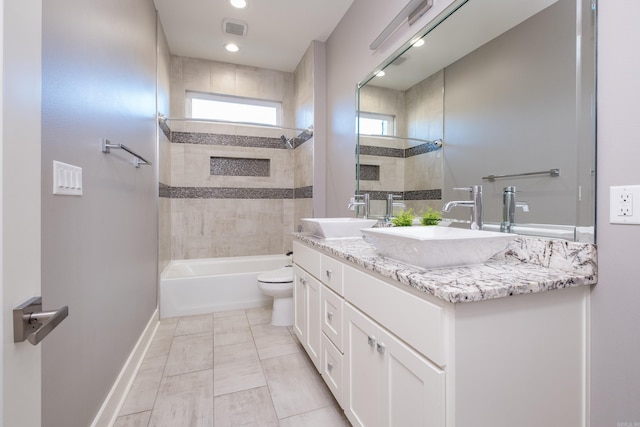 bathroom with double vanity, visible vents, toilet, and a sink