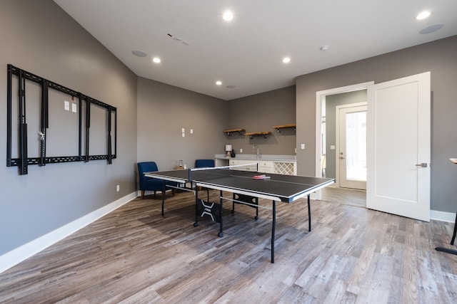 game room featuring light wood finished floors, recessed lighting, and baseboards