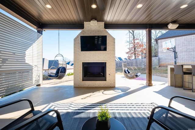 view of patio / terrace featuring fence and an outdoor brick fireplace