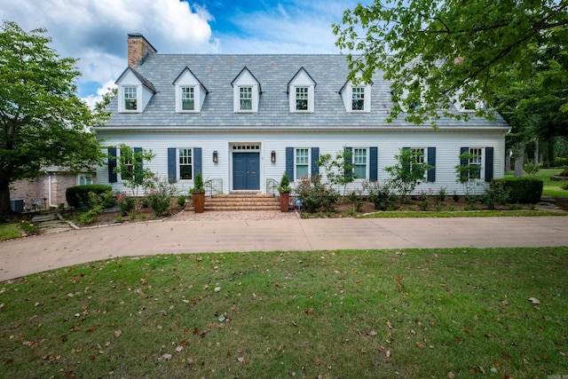 cape cod-style house featuring a high end roof, a chimney, and a front lawn