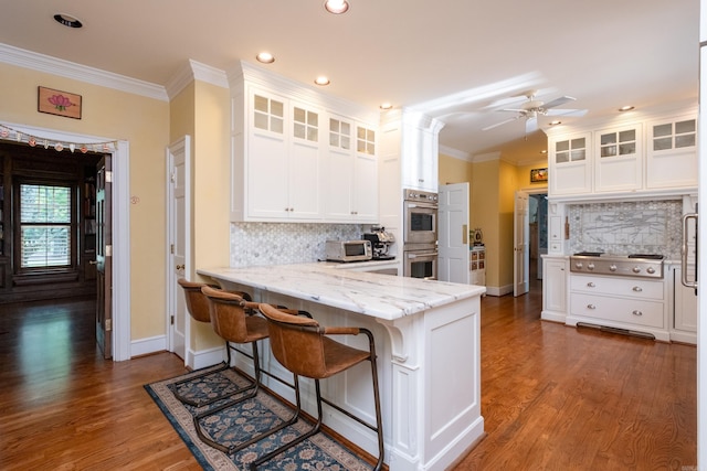 kitchen featuring stainless steel appliances, crown molding, and white cabinetry