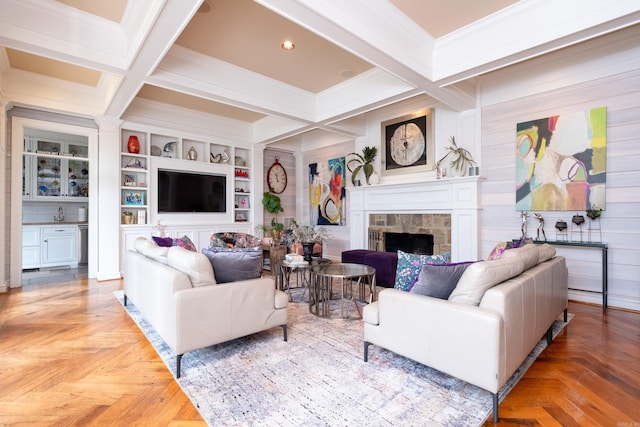 living area with beamed ceiling, built in shelves, ornamental molding, coffered ceiling, and a fireplace