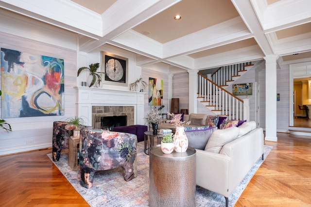 living room featuring stairway, coffered ceiling, ornamental molding, and a fireplace