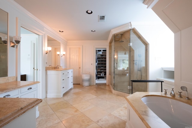 bathroom with a shower stall, two vanities, visible vents, and ornamental molding